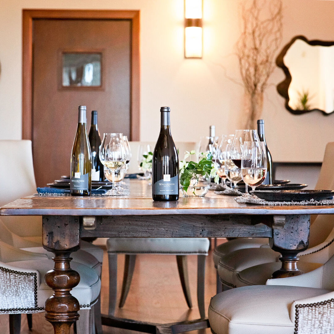 Various bottles of wine at WillaKenzie on wooden table in the estate lounge.